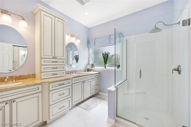 bathroom with double vanity, a stall shower, visible vents, and a sink