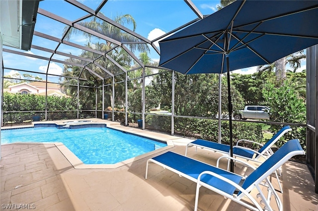 view of pool featuring a pool with connected hot tub, a lanai, and a patio