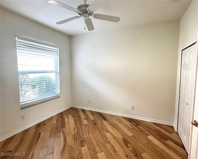 unfurnished bedroom with baseboards, a ceiling fan, and light wood-style floors