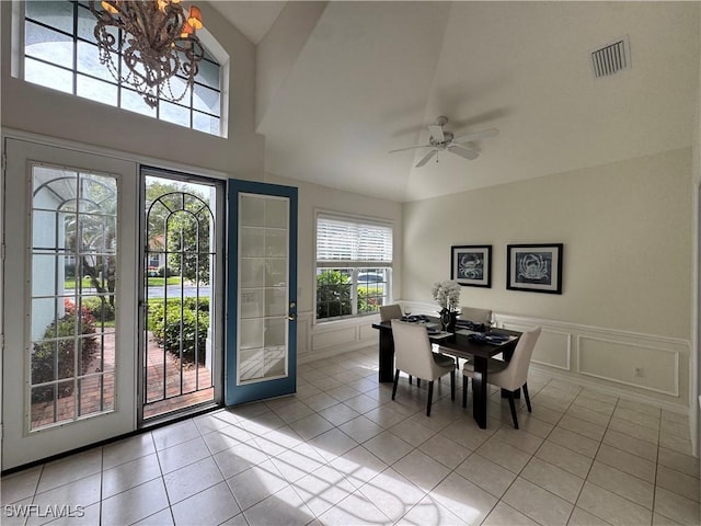 dining area featuring ceiling fan with notable chandelier, visible vents, a decorative wall, and light tile patterned floors