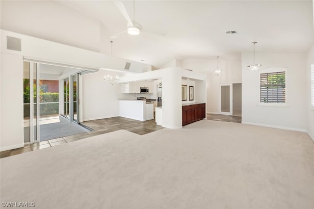 unfurnished living room with ceiling fan with notable chandelier