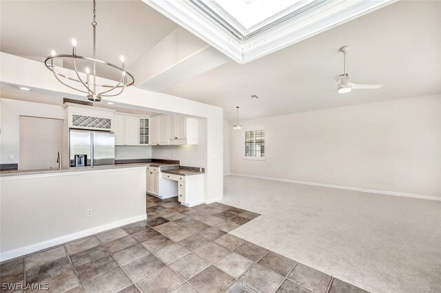 kitchen featuring dark carpet, stainless steel fridge, decorative light fixtures, and white cabinets