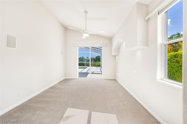 spare room featuring high vaulted ceiling, light colored carpet, and ceiling fan