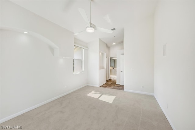 carpeted empty room featuring ceiling fan and lofted ceiling