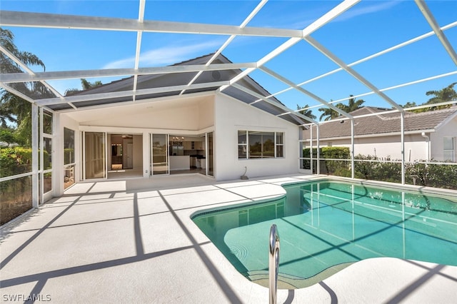 view of swimming pool featuring a patio and glass enclosure