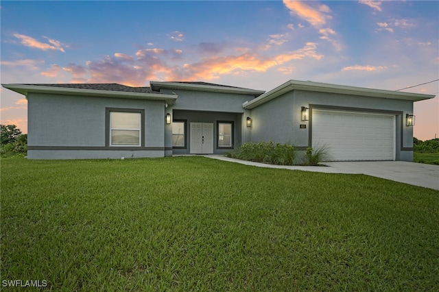 view of front of property featuring a yard and a garage