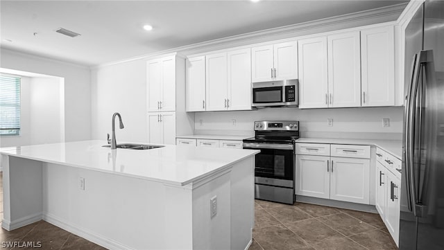 kitchen with stainless steel appliances, white cabinetry, a kitchen island with sink, and sink