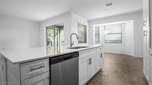 kitchen featuring sink, white cabinets, dark tile patterned flooring, stainless steel dishwasher, and crown molding