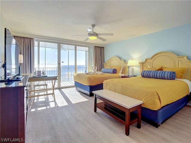 bedroom with ceiling fan, a water view, access to outside, and light wood-type flooring