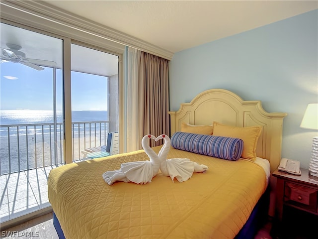 bedroom featuring ceiling fan, a water view, access to outside, and multiple windows