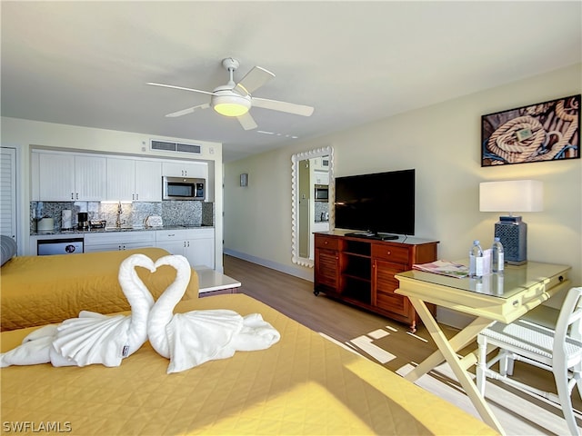 living room with ceiling fan and light hardwood / wood-style floors