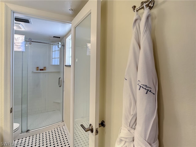 bathroom with toilet and a shower with shower door