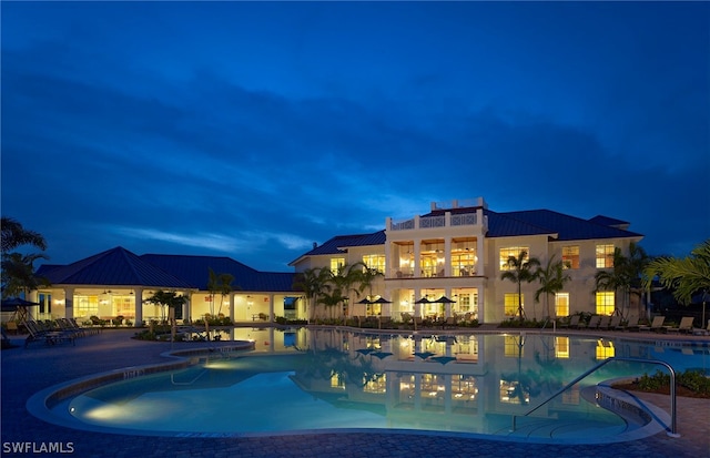 pool at twilight with a patio area