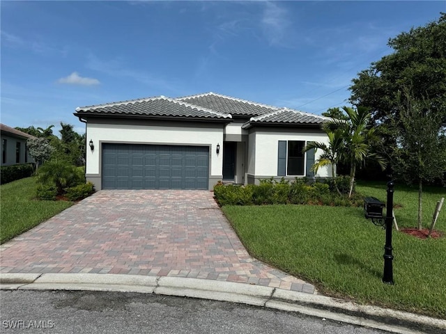 view of front of home featuring decorative driveway, stucco siding, an attached garage, a front yard, and a tiled roof