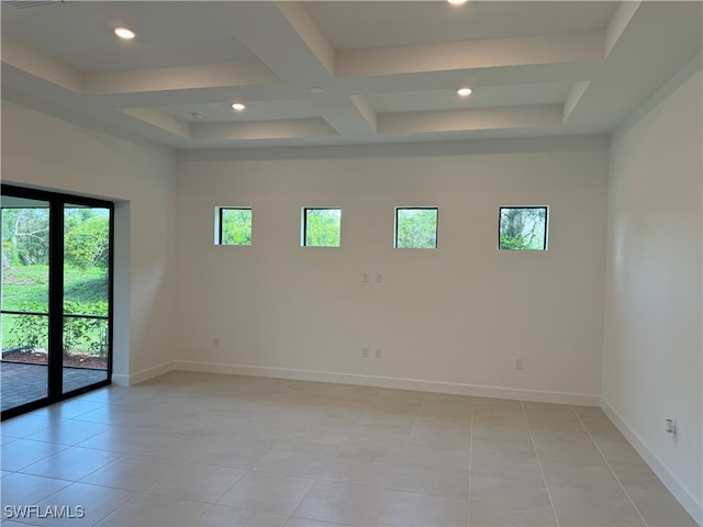 tiled spare room featuring coffered ceiling, plenty of natural light, and beamed ceiling