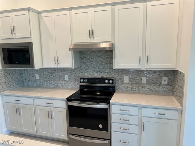 kitchen featuring light stone countertops, stainless steel appliances, decorative backsplash, and white cabinetry