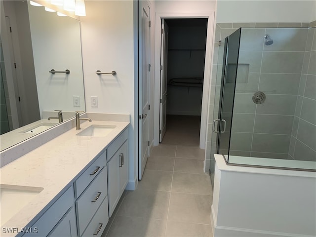 bathroom featuring vanity, a shower with shower door, and tile patterned floors