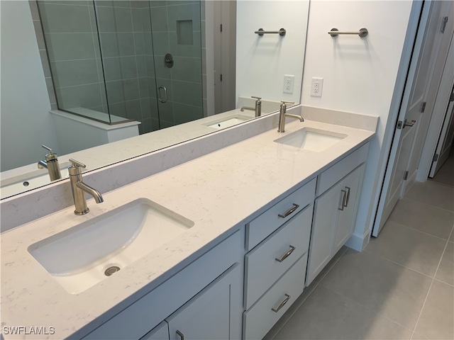 bathroom with tile patterned floors, a shower with door, and vanity