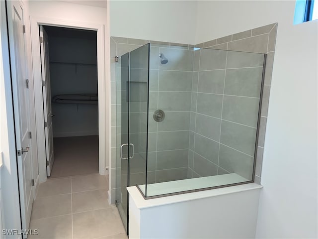 bathroom featuring a shower with shower door and tile patterned flooring