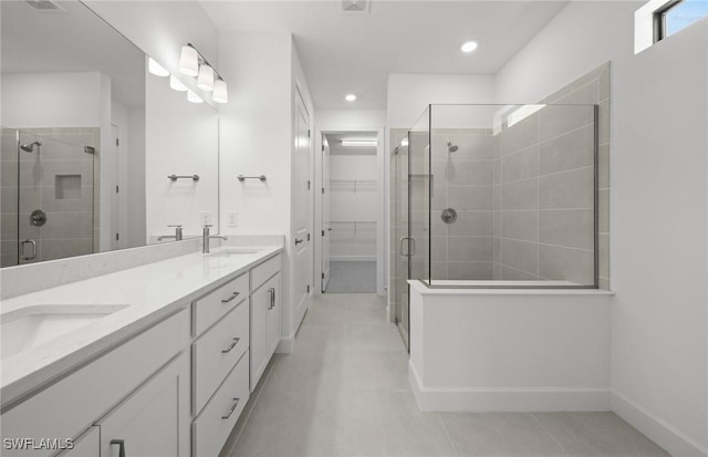 17161 Oakstead Dr, Alva, FL 33920 - bathroom with double vanity, a spacious closet, a sink, a stall shower, and tile patterned flooring