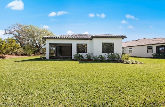 17161 Oakstead Dr, Alva, FL 33920 - back of property with stucco siding, a sunroom, a tiled roof, and a yard