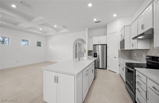 17161 Oakstead Dr, Alva, FL 33920 - kitchen with coffered ceiling, under cabinet range hood, backsplash, arched walkways, and appliances with stainless steel finishes