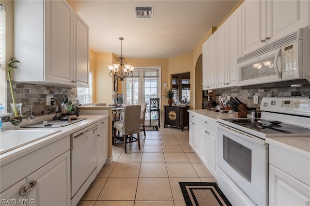 kitchen featuring white cabinetry, pendant lighting, light tile patterned floors, and white appliances