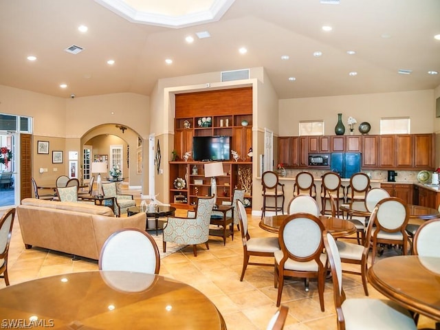 tiled dining area featuring high vaulted ceiling