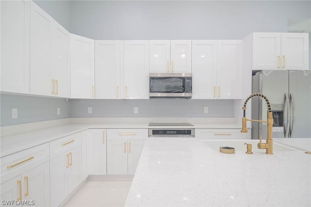 3211 12th St W, Lehigh Acres, FL 33971 - kitchen with white cabinets, stainless steel appliances, light stone countertops, and a sink