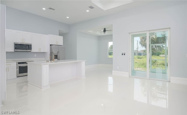 3211 12th St W, Lehigh Acres, FL 33971 - kitchen featuring white cabinets, stainless steel appliances, light countertops, visible vents, and a kitchen island with sink