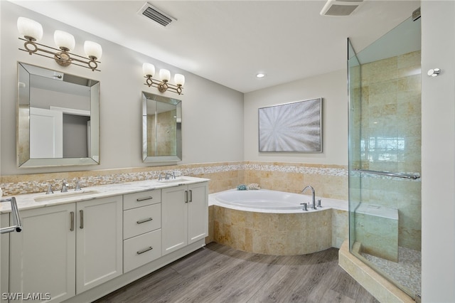 bathroom featuring plus walk in shower, hardwood / wood-style floors, and vanity