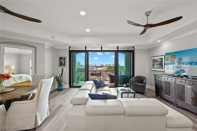 living room with crown molding, light hardwood / wood-style flooring, and ceiling fan