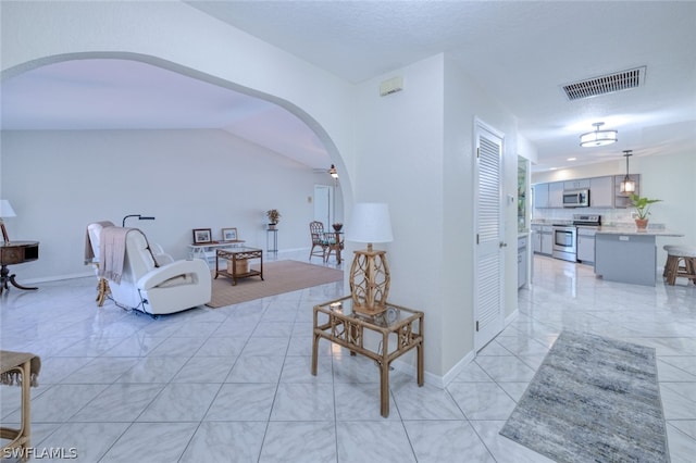 living room with vaulted ceiling and light tile patterned floors