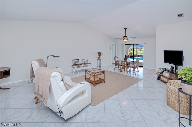 living room with lofted ceiling, ceiling fan, and light tile patterned floors