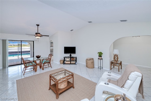 tiled living room with ceiling fan and vaulted ceiling