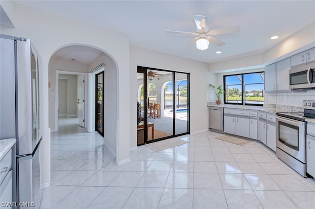 kitchen featuring decorative backsplash, appliances with stainless steel finishes, ceiling fan, and light tile patterned floors