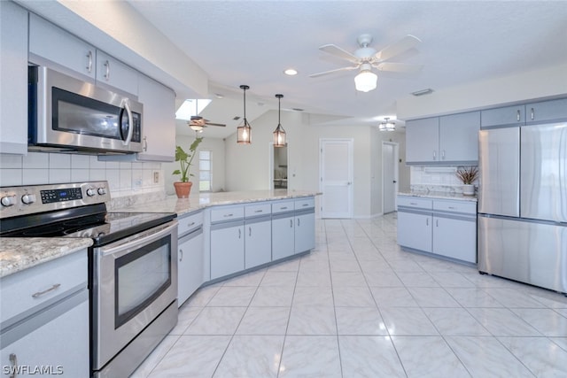 kitchen with appliances with stainless steel finishes, ceiling fan, kitchen peninsula, hanging light fixtures, and decorative backsplash