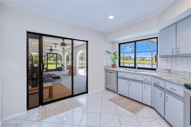 kitchen featuring decorative backsplash, dishwasher, a healthy amount of sunlight, and ceiling fan