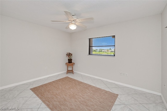 tiled spare room with ceiling fan