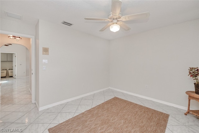 tiled spare room featuring ceiling fan