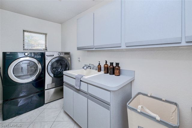 laundry area with separate washer and dryer, cabinets, light tile patterned floors, and sink