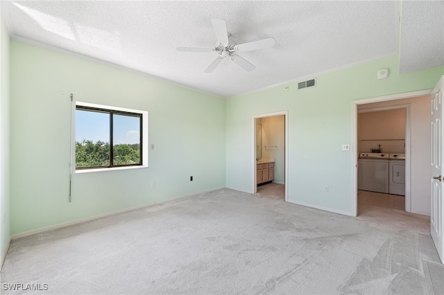 unfurnished bedroom featuring ceiling fan, independent washer and dryer, a textured ceiling, and ensuite bath