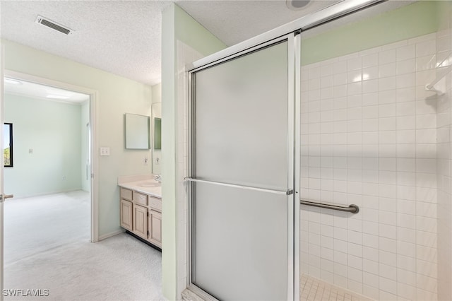 bathroom featuring vanity, a textured ceiling, and walk in shower