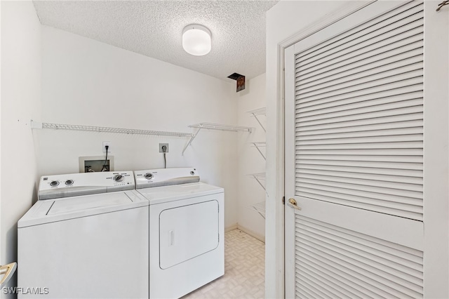 laundry room featuring washing machine and dryer and a textured ceiling