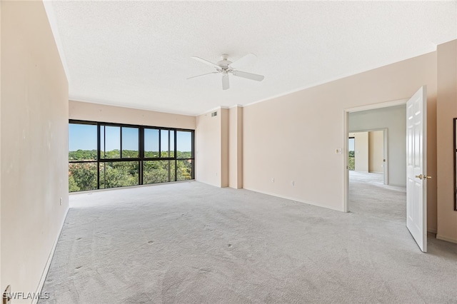 unfurnished room featuring light carpet, a textured ceiling, and ceiling fan