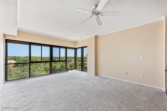 carpeted spare room with a textured ceiling, ceiling fan, and a healthy amount of sunlight