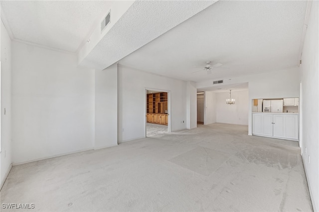 unfurnished living room with ceiling fan with notable chandelier, light colored carpet, and a textured ceiling