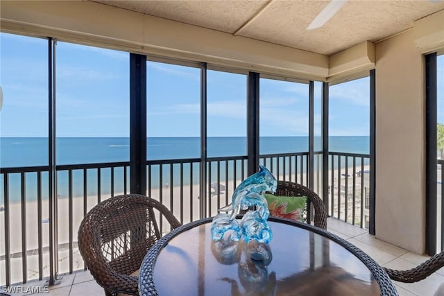 sunroom with a beach view and a water view