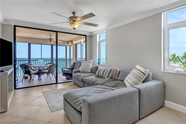 tiled living room with ornamental molding, ceiling fan, and a water view