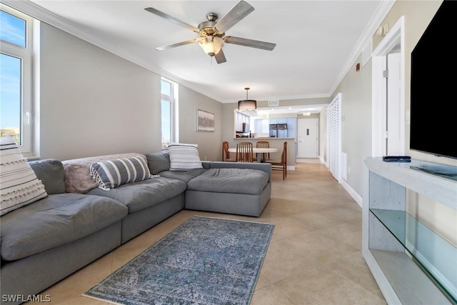 living room with light tile patterned floors, ornamental molding, and ceiling fan